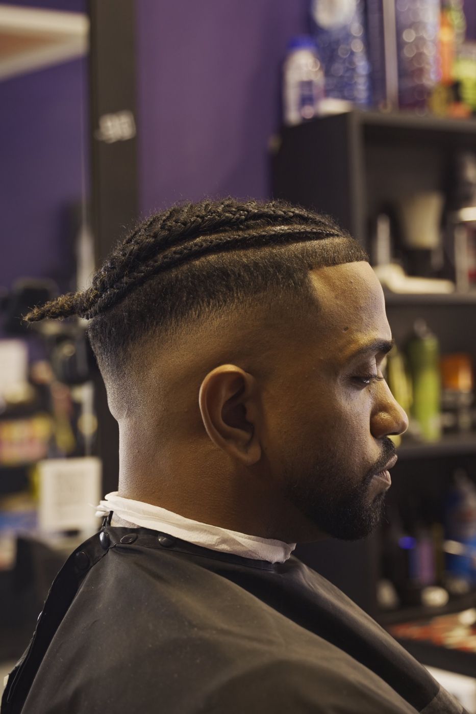 Client in profile with braids and a skin fade