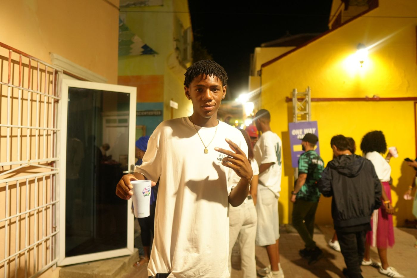 Young man in a white tee holding a festival cup