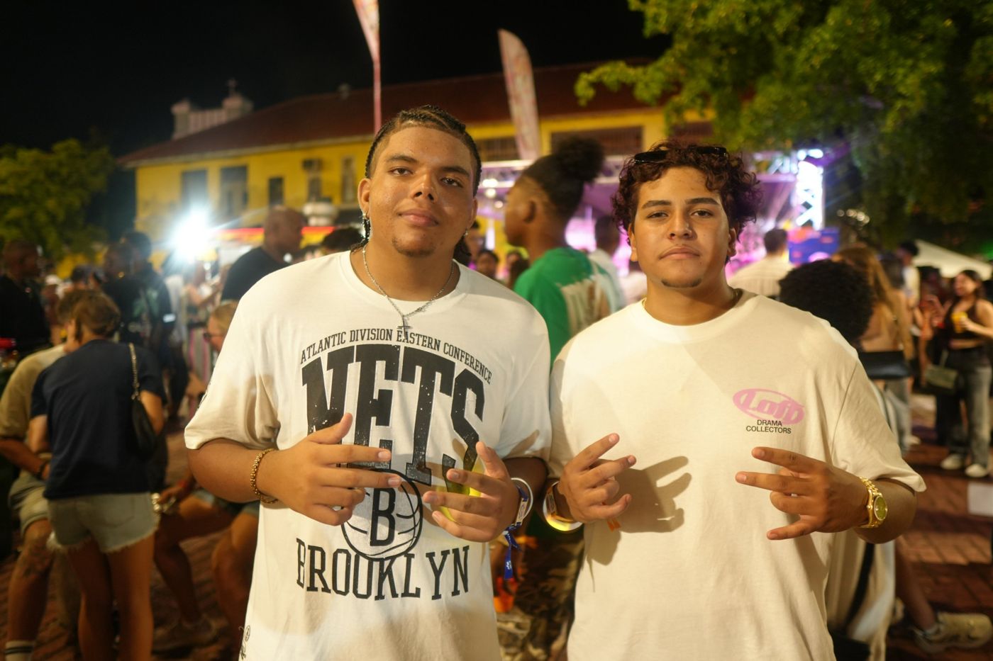 Two young men posing in front of a lit stage
